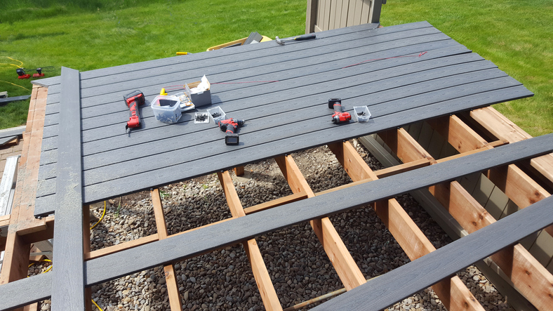 New deck constructed from a Composite Decking Material. PVC Gray plastic with a wood grain. Supports and beams are real wood,cedar.