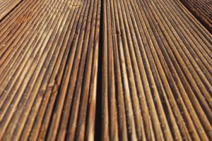 Perspective view of the wooden floor of a sea pier as a backdrop. Full-frame boardwalk. Blurred wood plank texture. Construction and Architecture
